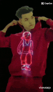 a man in a red hoodie is standing next to a neon drawing of a woman .