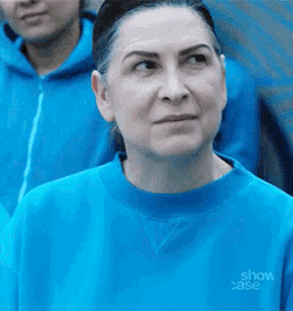 a woman wearing a blue sweatshirt with the word show case on it .