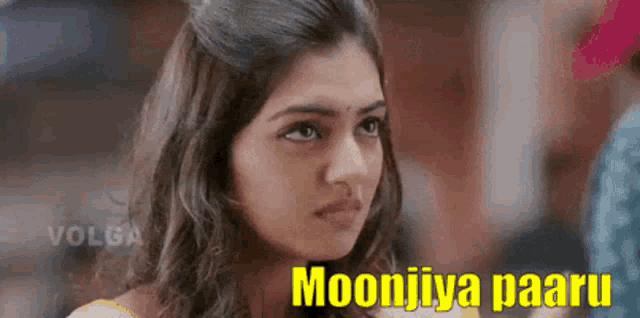 a close up of a woman 's face with the words moonjiya paaru written on the bottom .
