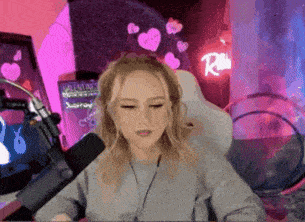 a woman is sitting in front of a microphone in a room with hearts on the wall .
