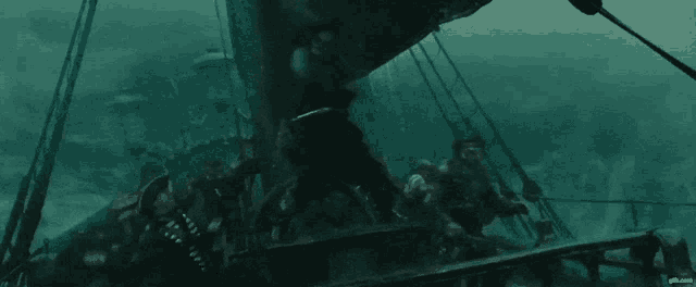 a group of people are standing on the deck of a ship in the water .