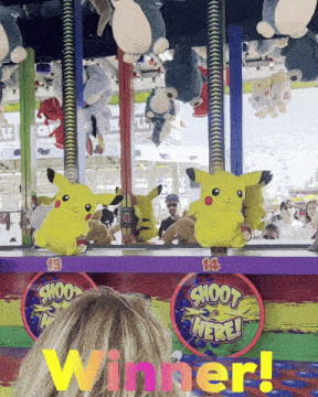 a woman is playing a game of shoot here with stuffed animals