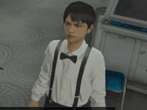 a man wearing suspenders and a bow tie is standing in front of a video game machine