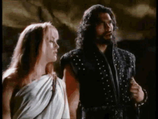 a man and a woman standing next to each other in a dark room .