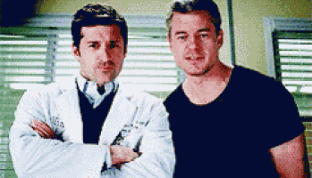 two men standing next to each other with their arms crossed .