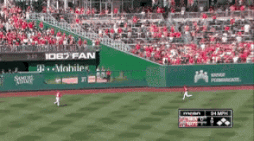 a baseball game is being played in front of a crowd with a banner that says 1067 fan