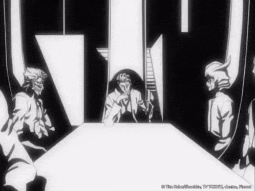 a group of men are sitting around a table in a room .