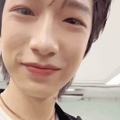 a close up of a person 's face with a necklace around his neck