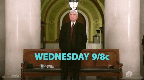 a man in a suit and tie stands in front of a bench that says wednesday 9/8c