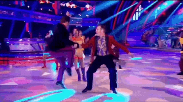 a group of people are dancing on a stage in a club .