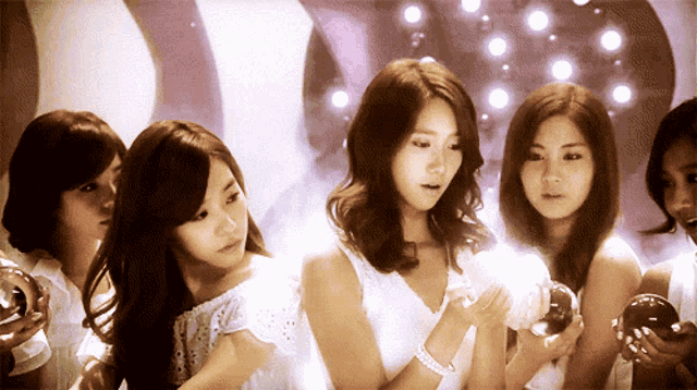 a group of young women are standing in a circle