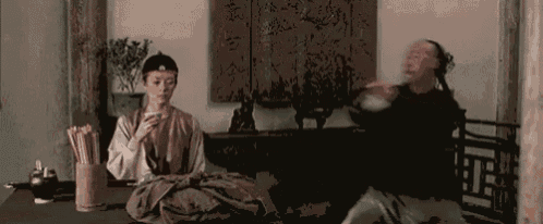 a man and a woman are sitting at a table in a living room .