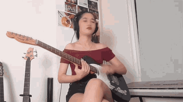 a woman wearing headphones playing a guitar