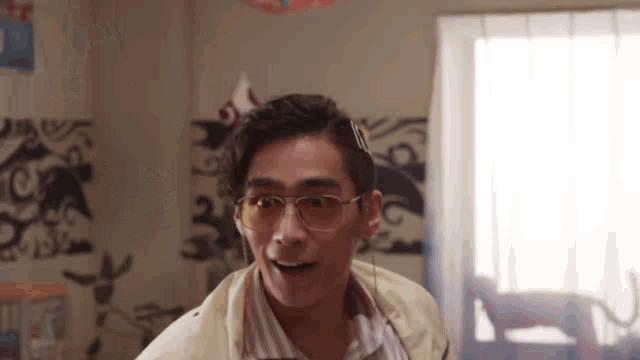 a man wearing glasses and headphones looks surprised in a room