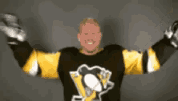 a hockey player with his arms outstretched is wearing a black and yellow jersey