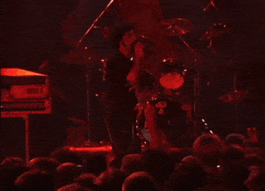 a man singing into a microphone while wearing a shirt that says " pig "