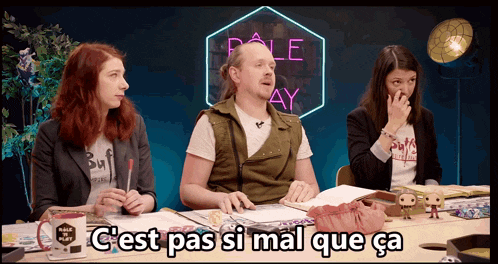 a group of people sitting at a table with the words c'est pas si mal que ca on the screen