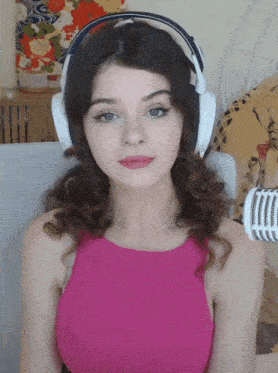 a woman in a pink top is wearing headphones