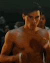 a shirtless man is standing in a boxing ring with a bandage on his hand .