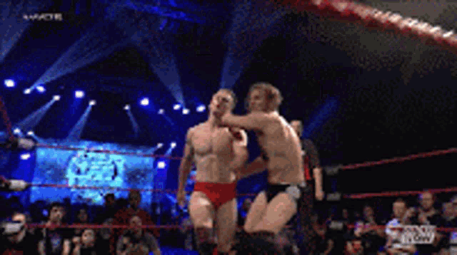 two men in a wrestling ring with the word nxt on the bottom right