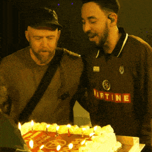 a man wearing a martine jersey stands next to another man