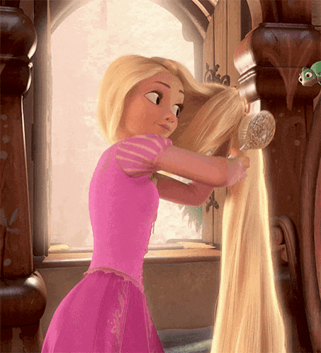 a girl in a pink dress brushing her hair