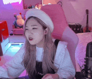 a girl wearing a white beret is sitting in a pink chair in front of a microphone