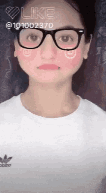 a girl wearing glasses and a white shirt with the word adidas on the front