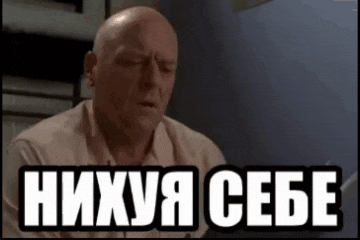 a bald man is sitting at a table with his eyes closed and a foreign language written on the screen .
