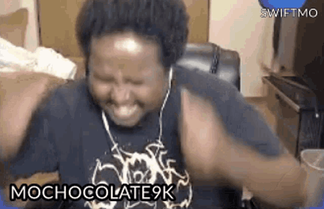 a man wearing headphones is making a funny face while sitting in a chair with his hands in the air .