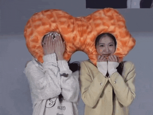 a girl wearing a shirt that says est.2019 stands next to another girl wearing a donut hat