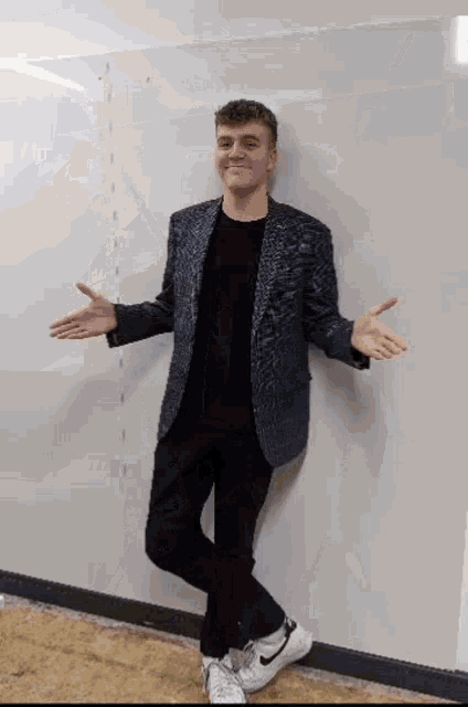 a man in a suit is standing in front of a white board .