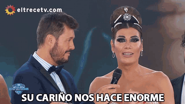 a woman speaking into a microphone with the words su carino nos hace enorme