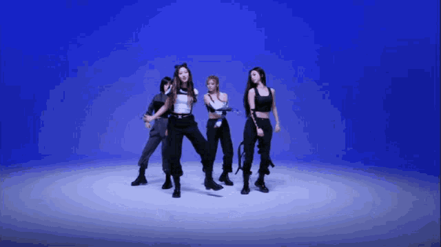 a group of women are dancing in front of a blue backdrop