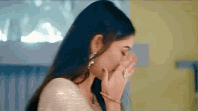 a close up of a woman covering her face with her hand .