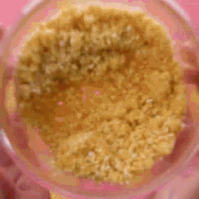 a person is using a spoon to spread crackers in a square pan