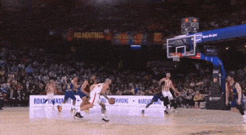 a basketball game is being played in front of a banner that says por meritxell