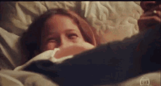 a little girl laying on a bed with a man