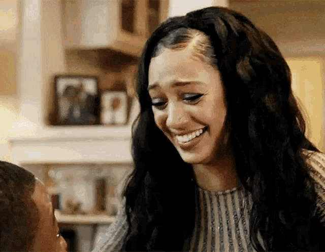 a woman is smiling and looking at another woman .