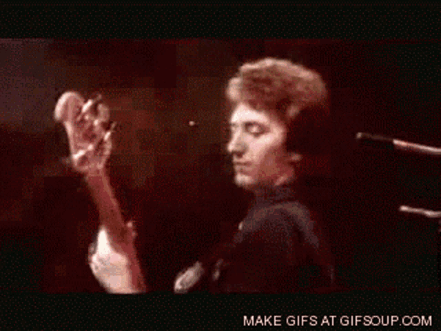 a gif of a man singing into a microphone with the words make gifs at gifsoup.com