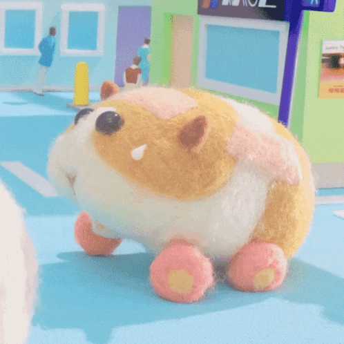 a yellow and white stuffed animal with pink wheels is on a street