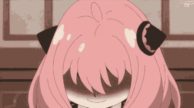 a girl with pink hair and black ears is smiling
