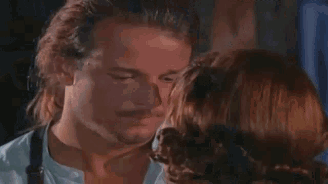 a man and a woman are looking at each other and the woman is covering her mouth with her hand .