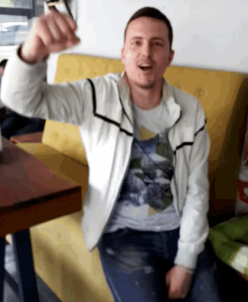 a man in a white jacket is sitting on a couch