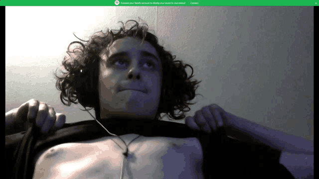 a screen shot of a man with headphones and a green screen that says connect your spotify account to display your music in your email