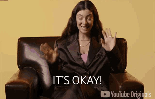 a woman sitting in a chair with the words it 's okay on the bottom right