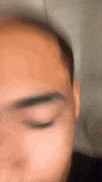 a close up of a man 's face with his eye closed