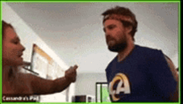 a man wearing a rams shirt is talking to a woman on a video call