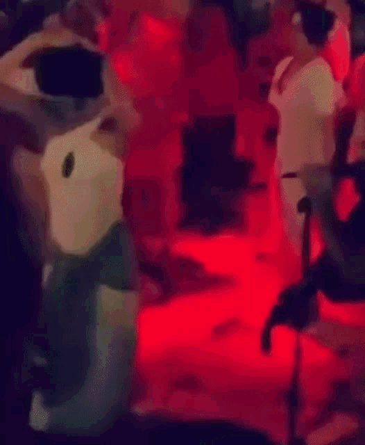 a blurry picture of people dancing in a dark room