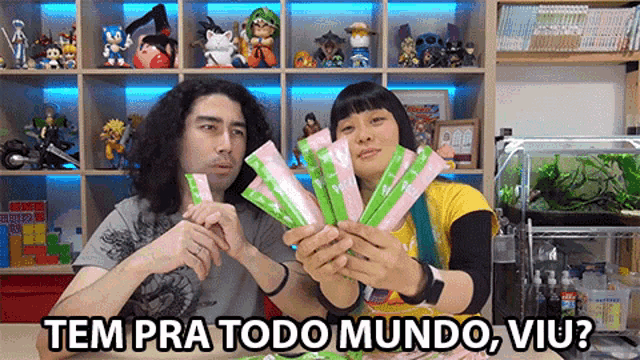 a man and a woman are holding a bunch of packets with the words tem pra todo mundo viu written below them